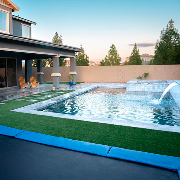 piscina privada con cascada junto a cama elástica