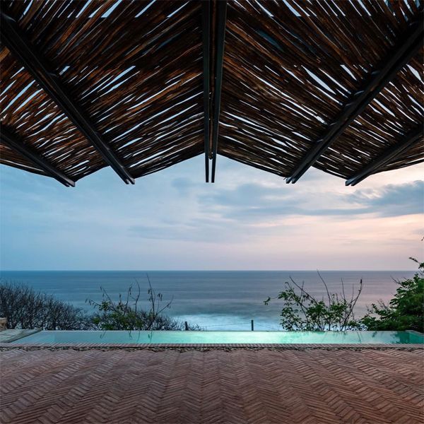 sea view at sunset from an infinity pool of a rustic design house project, by Espacio 18 Arquitectura