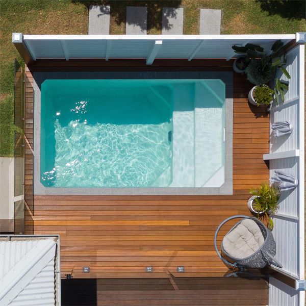 Drone view of a white mini pool by South Coast Plunge Poolsin a small backyard with wooden decking
