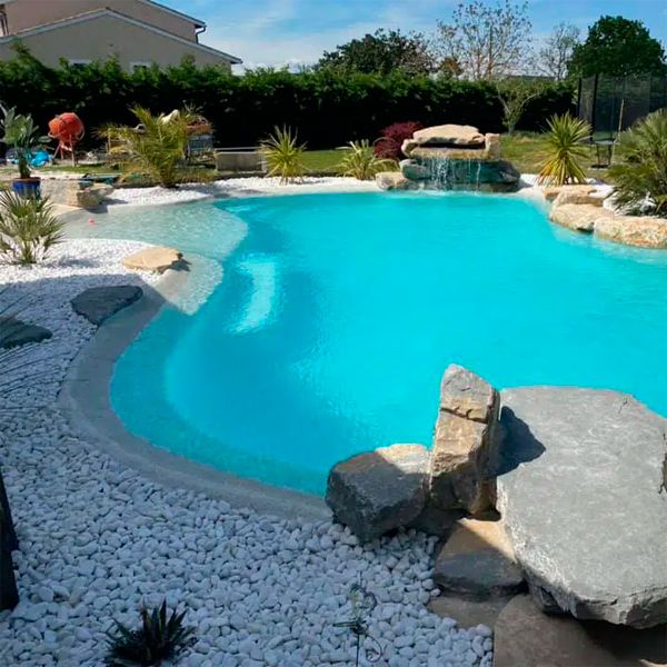 Custom lagoon pool, beach style, in a private garden, by Piscines HDP