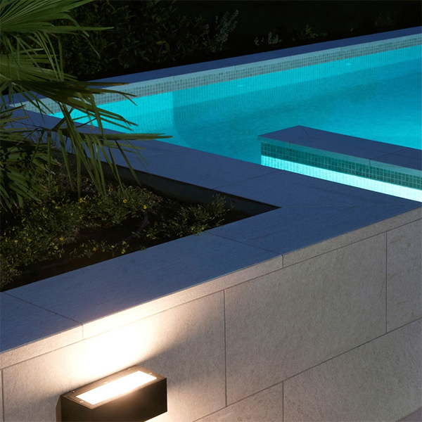 piscina infinita iluminada de formas rectas en la montaña