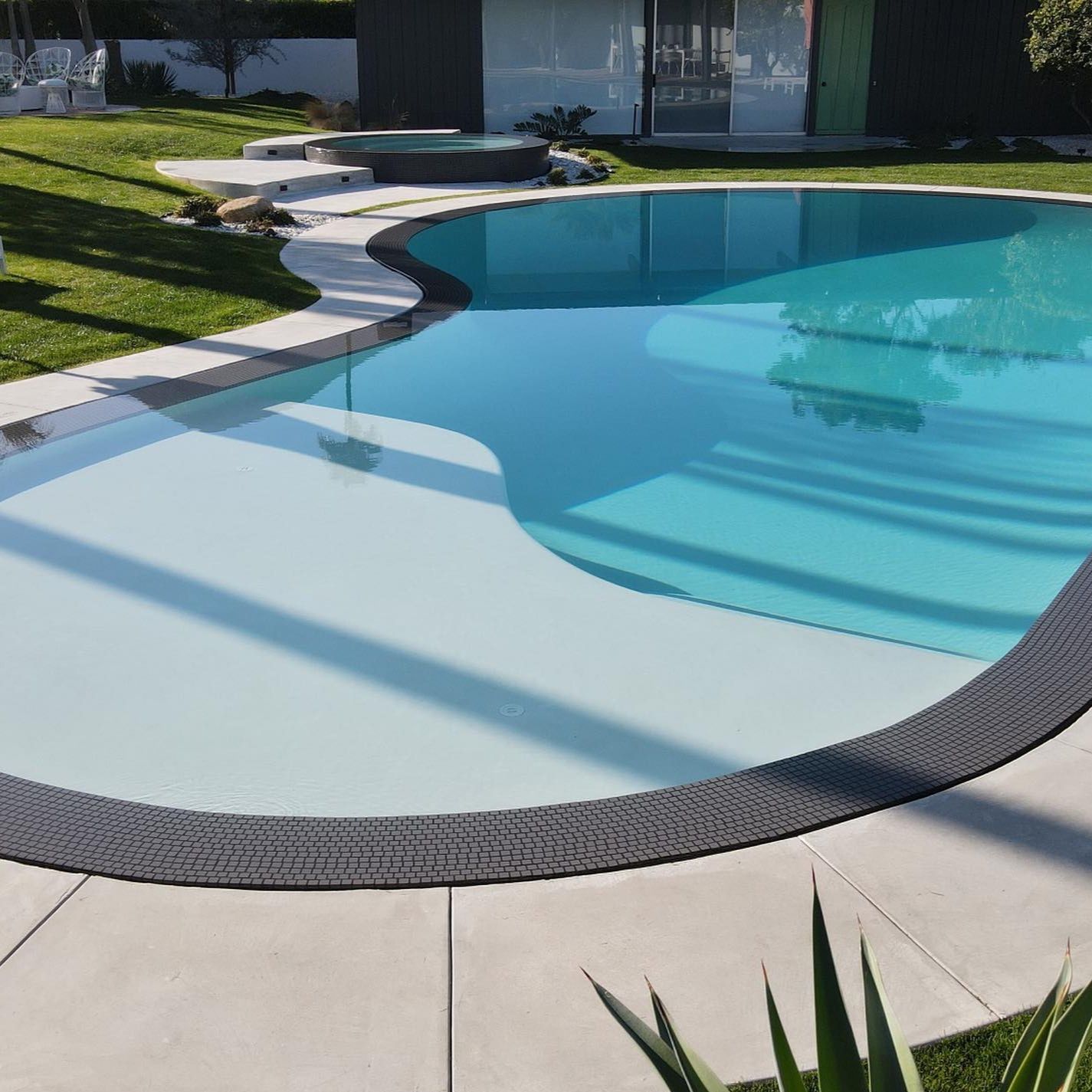 overflow pool with white interior coating and contrasting dark overflowing edge, by MPS Builders