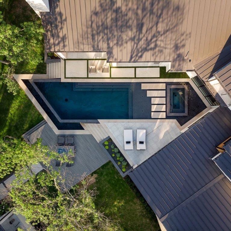 Drone view of an infinity pool with built-in spa and a unique design, based on straight lines and angles, by Pool Environments