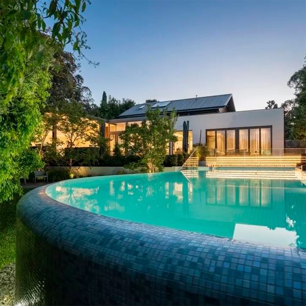Illuminated custom infinity pool at night, by Coolabah Landscape