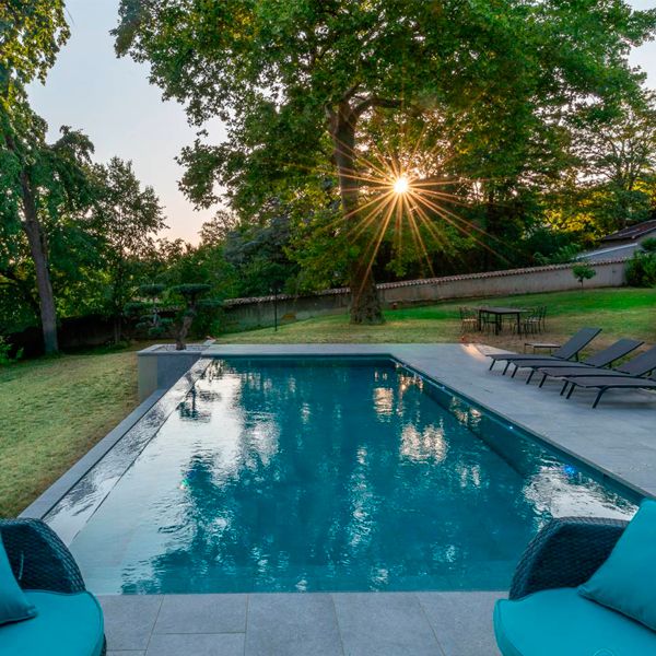 stylish infinity pool with mobile floor, at sunset, by Côté Jardin
