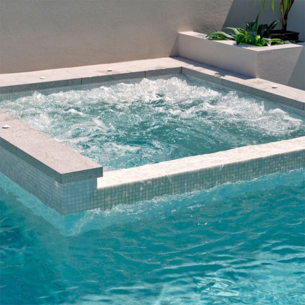 overflow spa with bubbles, in a private pool by Queensland Family Pools and Spas