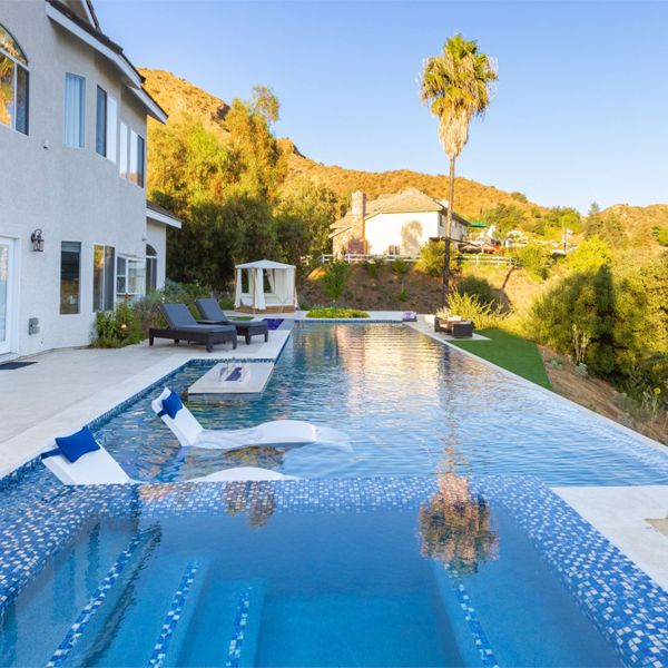 infinity pool with built-in spa, in a landscaping project in a hill, by Green Scene Landscaping