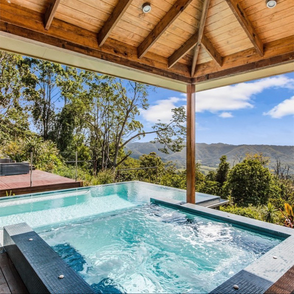 infinity pool and overflow spa with transparent wall by Dynamic Pool Designs