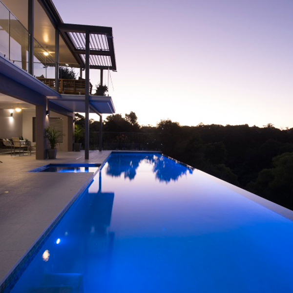 lap infinity pool and spa at night by Vision Pools