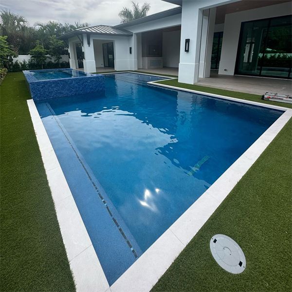 Custom geometric swimming pool with raised overflow spa, by Chief Pools Plastering
