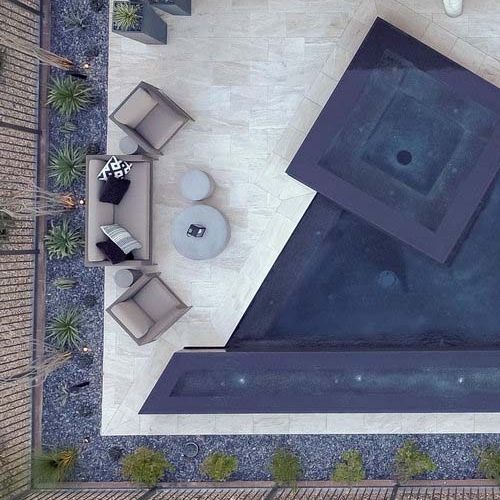 Drone view of a custom geometric infinity pool with built-in spa by California Pools