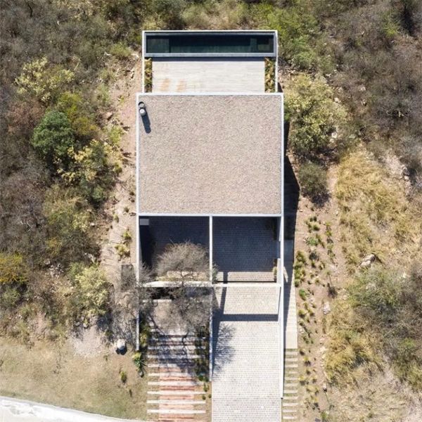 Drone view of a modern and minimalist house with an infinity pool, by Gaston Sironi Arquitectos