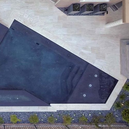 Drone view of a custom geometric infinity pool, by California Pools