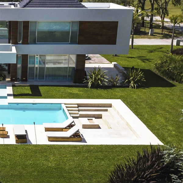 piscina rectangular clásica con zona de playa y zona de reunión contigua