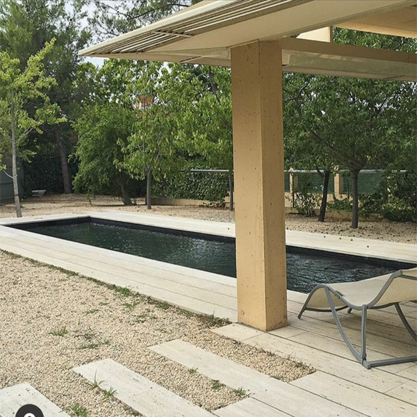 Piscina privada negra con mármol travertino