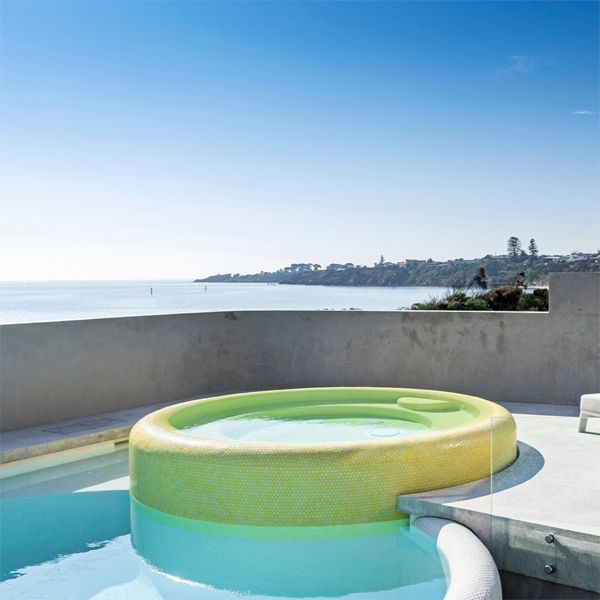 a unique custom pool with a yellow spa, by Enki Pools