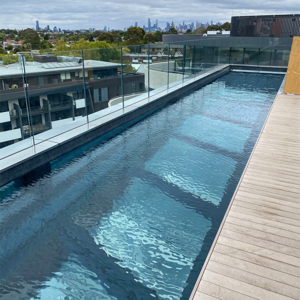 transparent bottom in a suspended lap pool betweeen two blocks of buildings by Aloha Pools