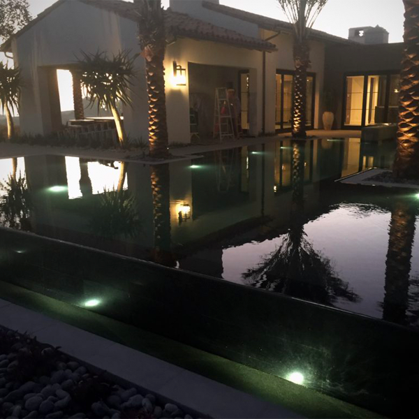 Outdoor living with infinity pool at sunset by Creative Atmospheres