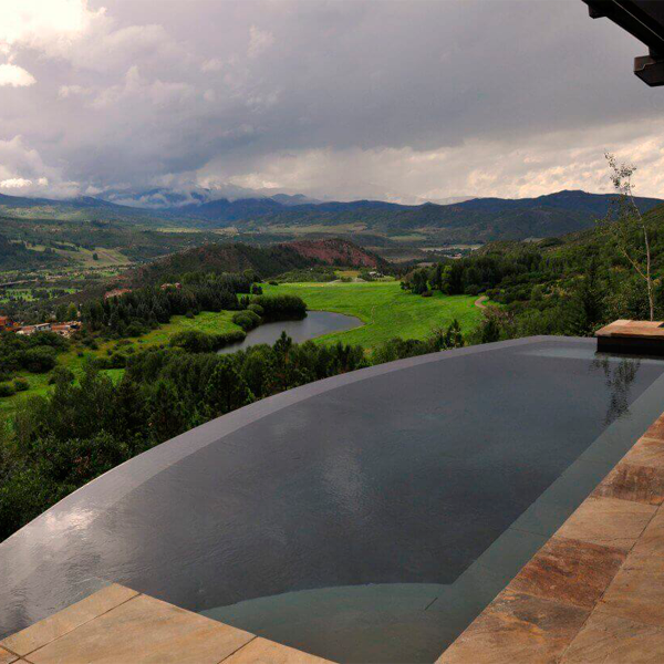 Rounded infinity pool by Colorado Pool Scapes