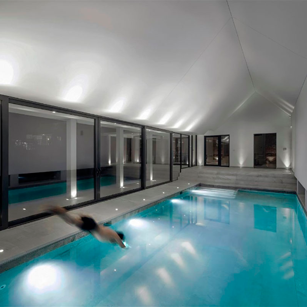 piscina interior con cristalera al jardín