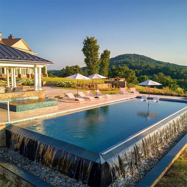 Classic design infinity pool, with overflowing space on a slope, and independent spa, also overflowing, in a project by Colao & Peter