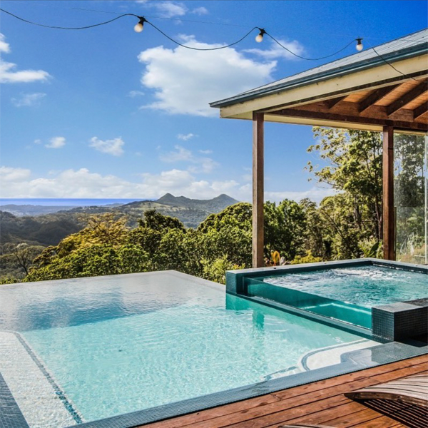 infinity pool and overflow spa with transparent wall by Dynamic Pool Designs