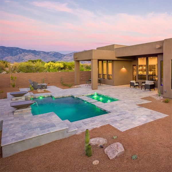Custom geometric pool with a built-in spa, in a backyard, in a single-family house in the middle of the desert, by Pools by Design, at sunset