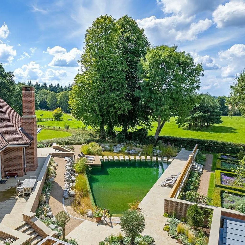 Drone view of a beautiful natural pool, exclusive geometric designed by Gartenart, in a country house with a modern garden adapted to the environment