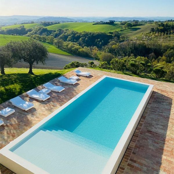 drone view of an Infinity white pool, with a minimalist design, in a rustic space, in the middle of the countryside, from a project by Wespi de Meuron Romeo Architetti