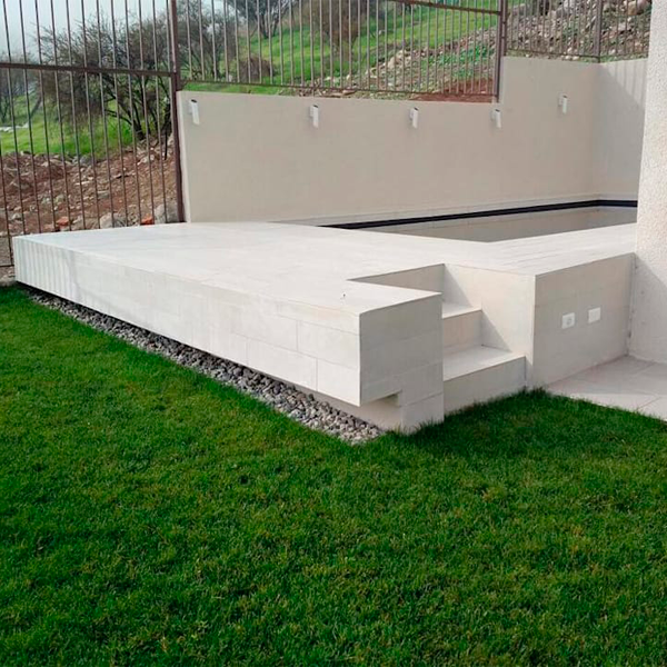 piscina elevada en casa individual con piedra blanca
