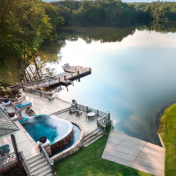 Drone view of a custom infinity mini pool spa, by Crystal Pools, in a house by the lake
