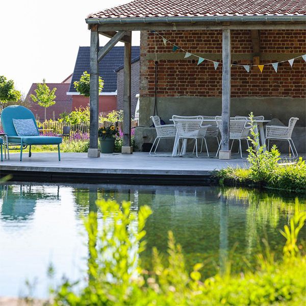 Natural pool and wooden deck by Tuinwerken Willemsens