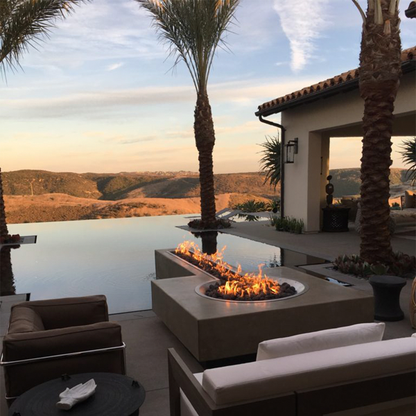Outdoor living with infinity pool at sunset by Creative Atmospheres
