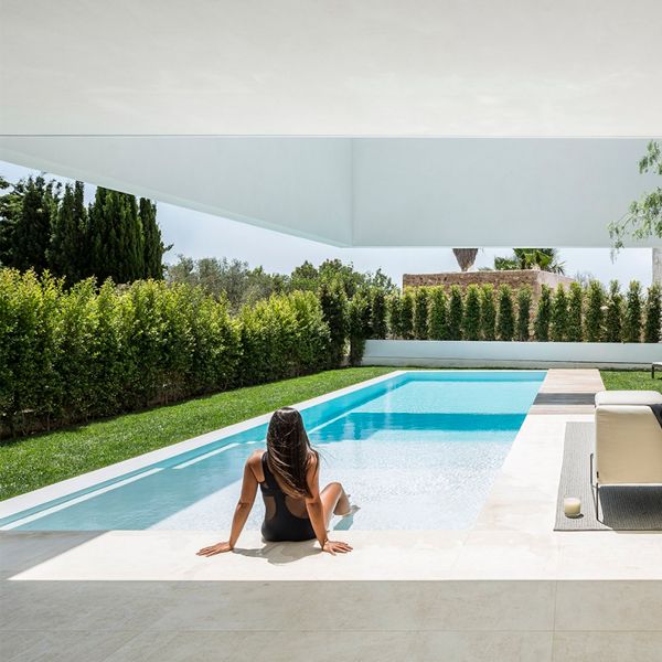 woman in a white minimalist infinity pool, in a project by Gallardo Llopis