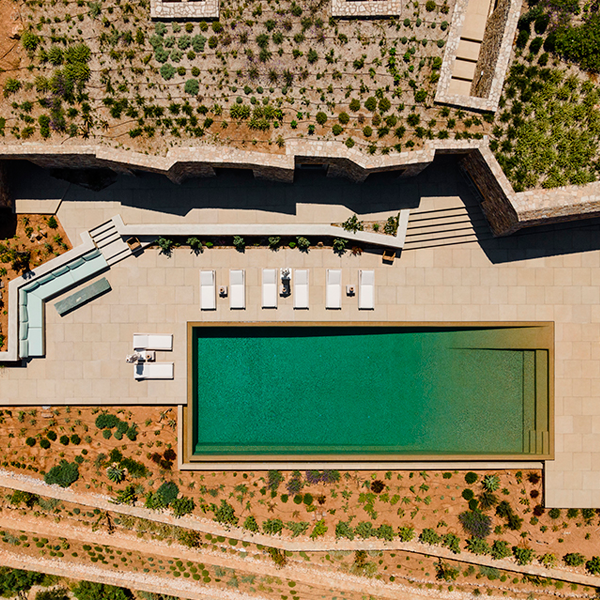 drone view of an impressive infinity pool of a private villa on the mountain in Greece, by Tsolakis Architects