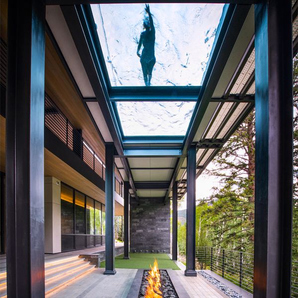 woman swimming in a suspended stainless steel lap pool with a transparent floor, by Colorado Pool and Spa