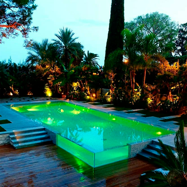 piscina elevada con esquina transparente por la noche