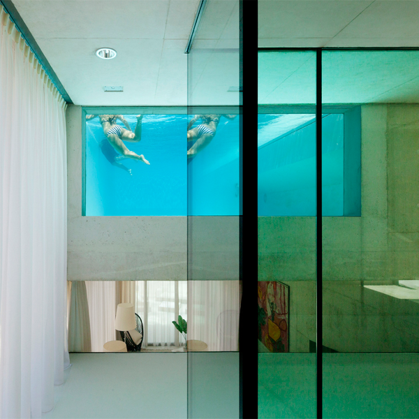 ventana de piscina con personas nadando vista desde el interior de la vivienda