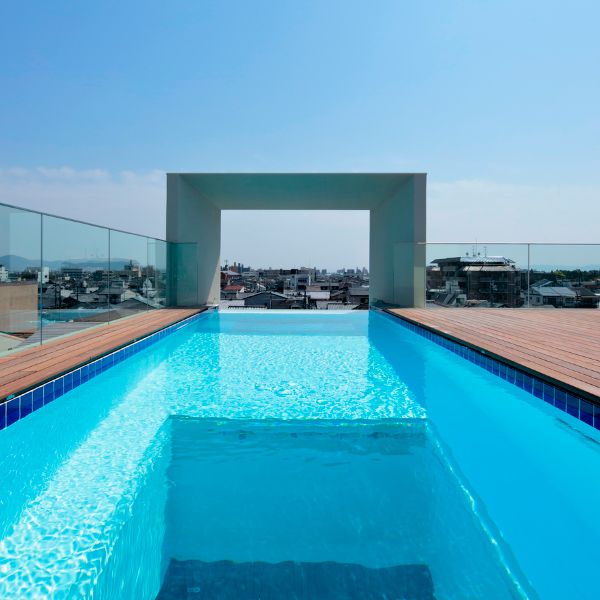 Infinity pool with windows on the floor, and an exterior arch, which acts as a picture frame, located on the terrace of a modern housing project, minimalist style, by Eastern Design Office