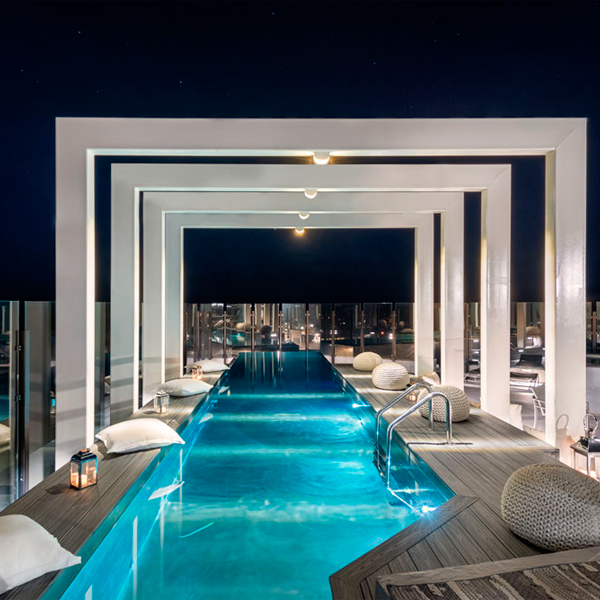 stainless steel infinity lap pool, by Diamond Spas, in a rooftop at night