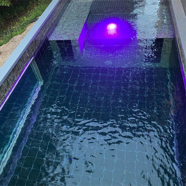 lighted mini pool with an underwater window by Via Pools