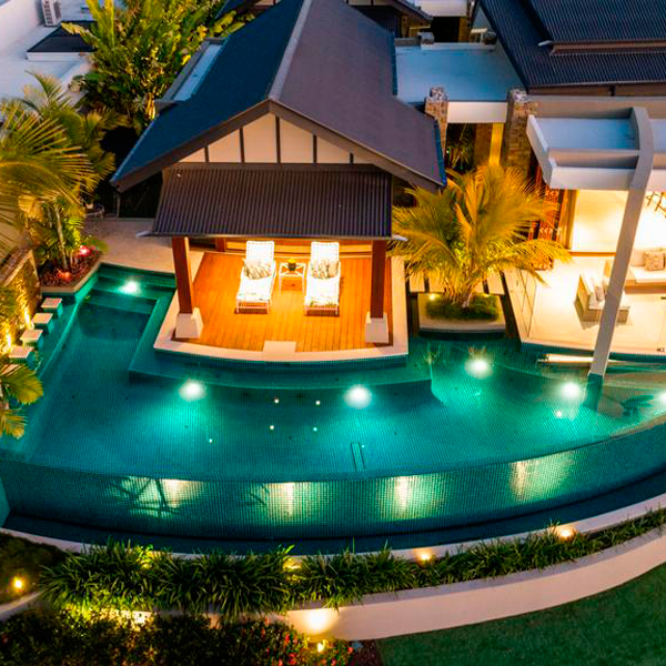 green infinity pool at night by JB Pool Construction