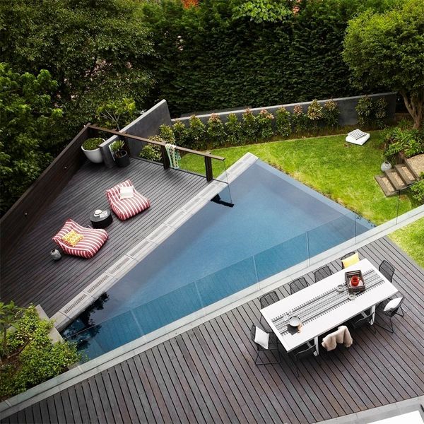Drone view of an original trapezoidal infinity pool, in a Harrisons Landscaping project with different heights and wooden decking terraces