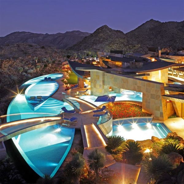drone view at night of an impressive project of different customized pool spaces with an ultra modern design, by A & N Pools in Palm Desert (California)