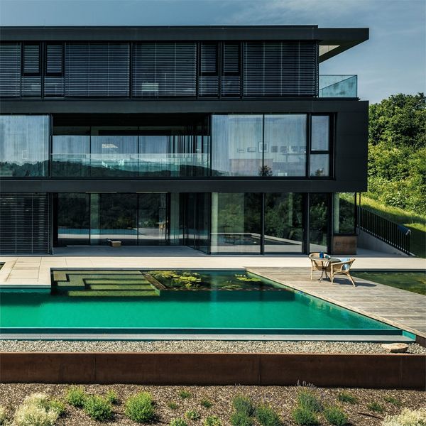 drone view of a natural infinity pool, by Biotop, in a house with a modern and minimalist design
