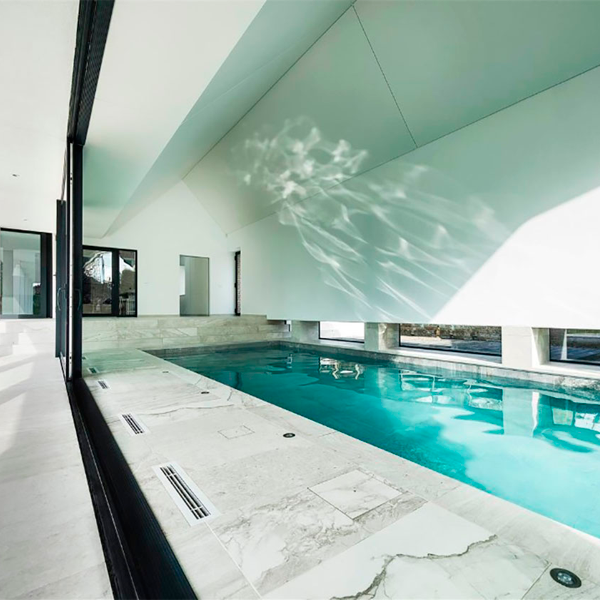 piscina interior con cristalera abierta al exterior
