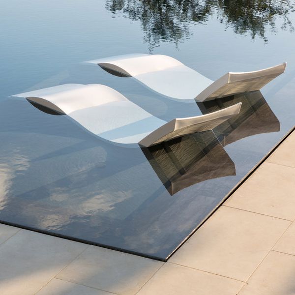 sun loungers inside a mirror pool, ina project by Murray Legge Architecture