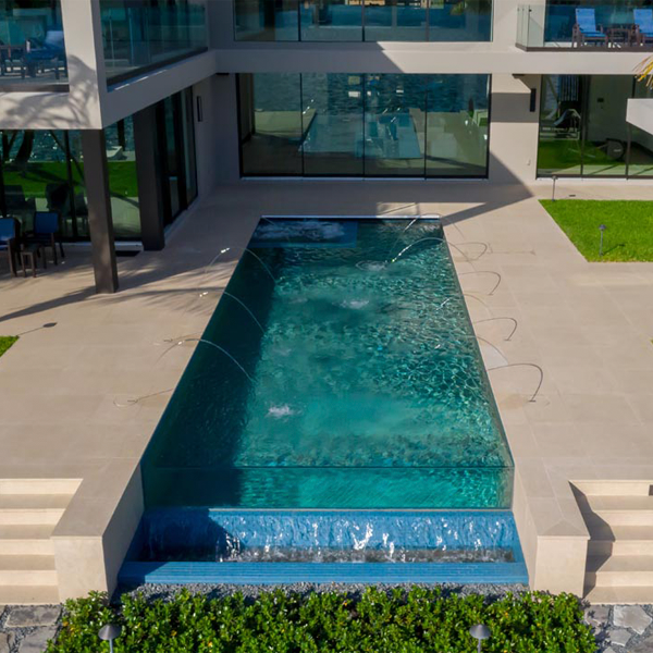 infinity pool with transparent wall drone view by Somar Pools