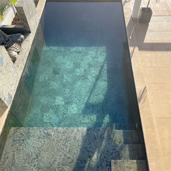 drone view of a Zen design private mini pool by Sarana Pools, with waterfalls and natural stone coating