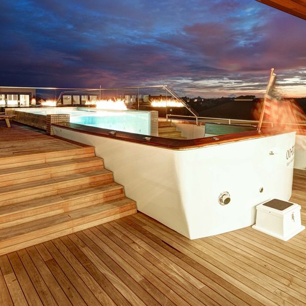 Infinity mini pool, with transparent wall, in the rooftop (nautical style) of a modern house, by Kersting Architecture, at night